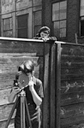 filming, facing forward, one looking over fence